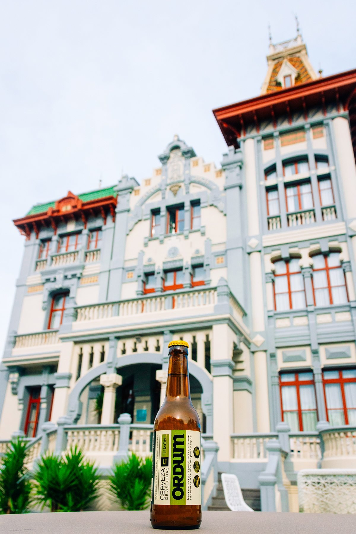 Ayalga x Ordum: botella de Ordum en primer plano con la fachada del edificio al fondo