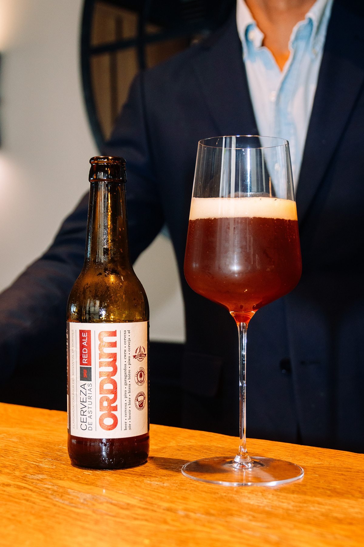 Ayalga x Ordum: botella de Ordum y copa de cerveza en una barra de madera