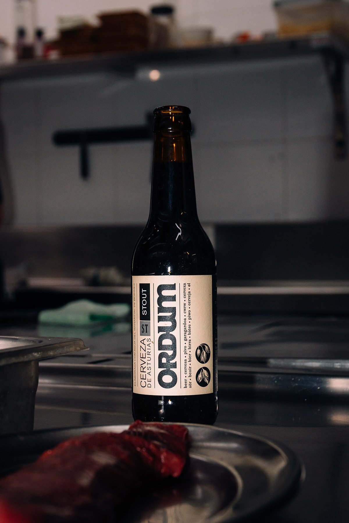 Ayalga x Ordum: botella de Ordum en la cocina con carne cruda en primer plano