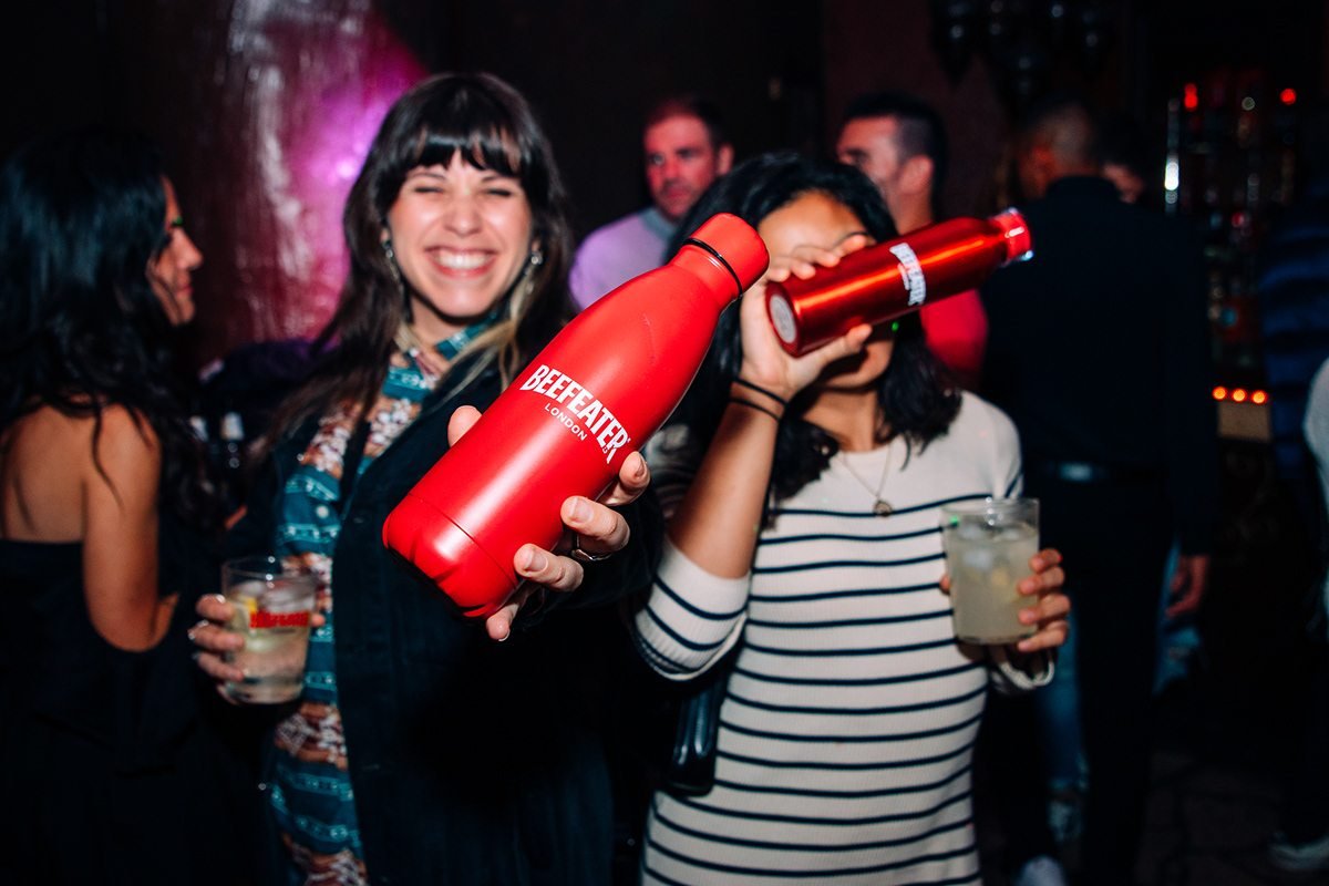 Beefeater London: invitadas sonriendo con una botella térmica roja en la fiesta