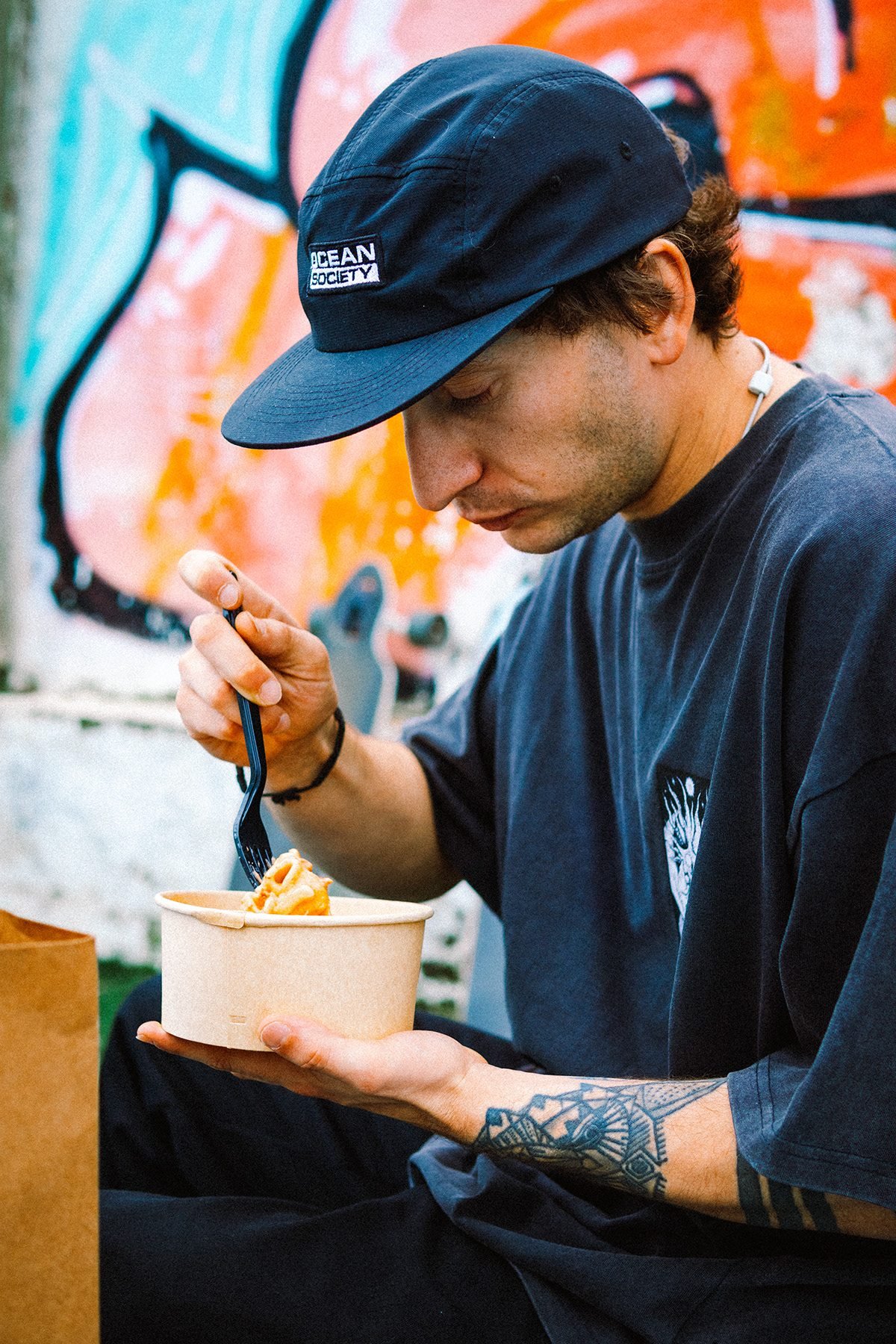 Gula: hombre con gorra comiendo de un bol de cartón, en primer plano