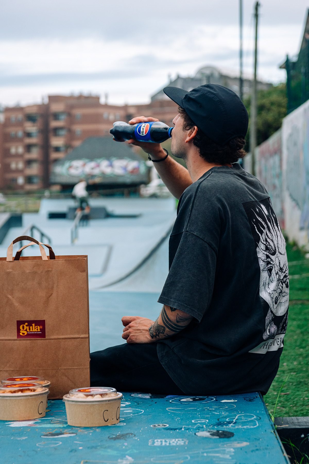 Gula: hombre bebiendo junto a una bolsa y boles de Gula en un skatepark