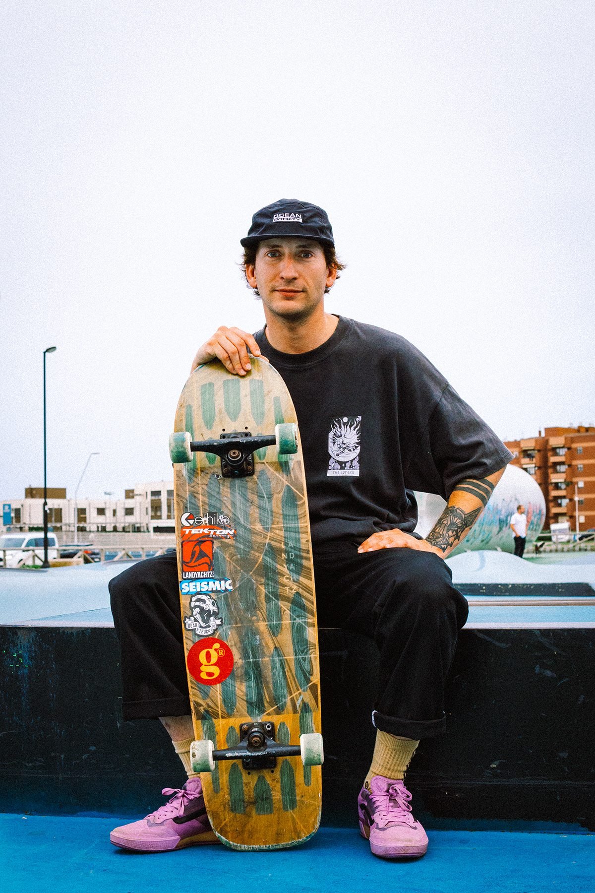 Gula: hombre con gorra sentado con un monopatín en un skatepark