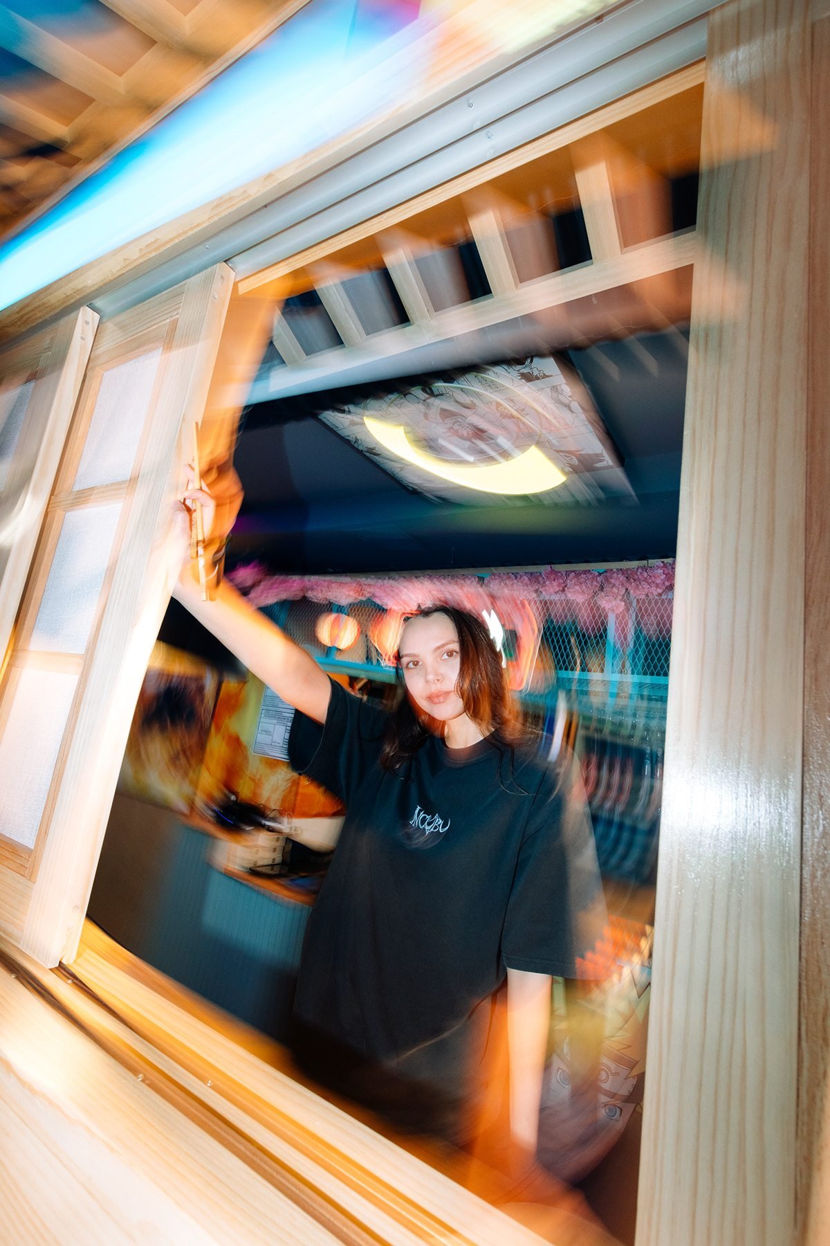 Incubu Clothing: modelo con camiseta negra tras una ventana de madera, con efecto de movimiento