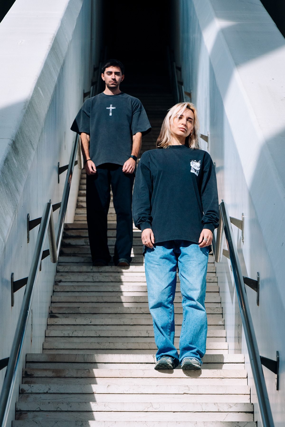 Incubu Clothing: dos modelos con camisetas negras en una escalera