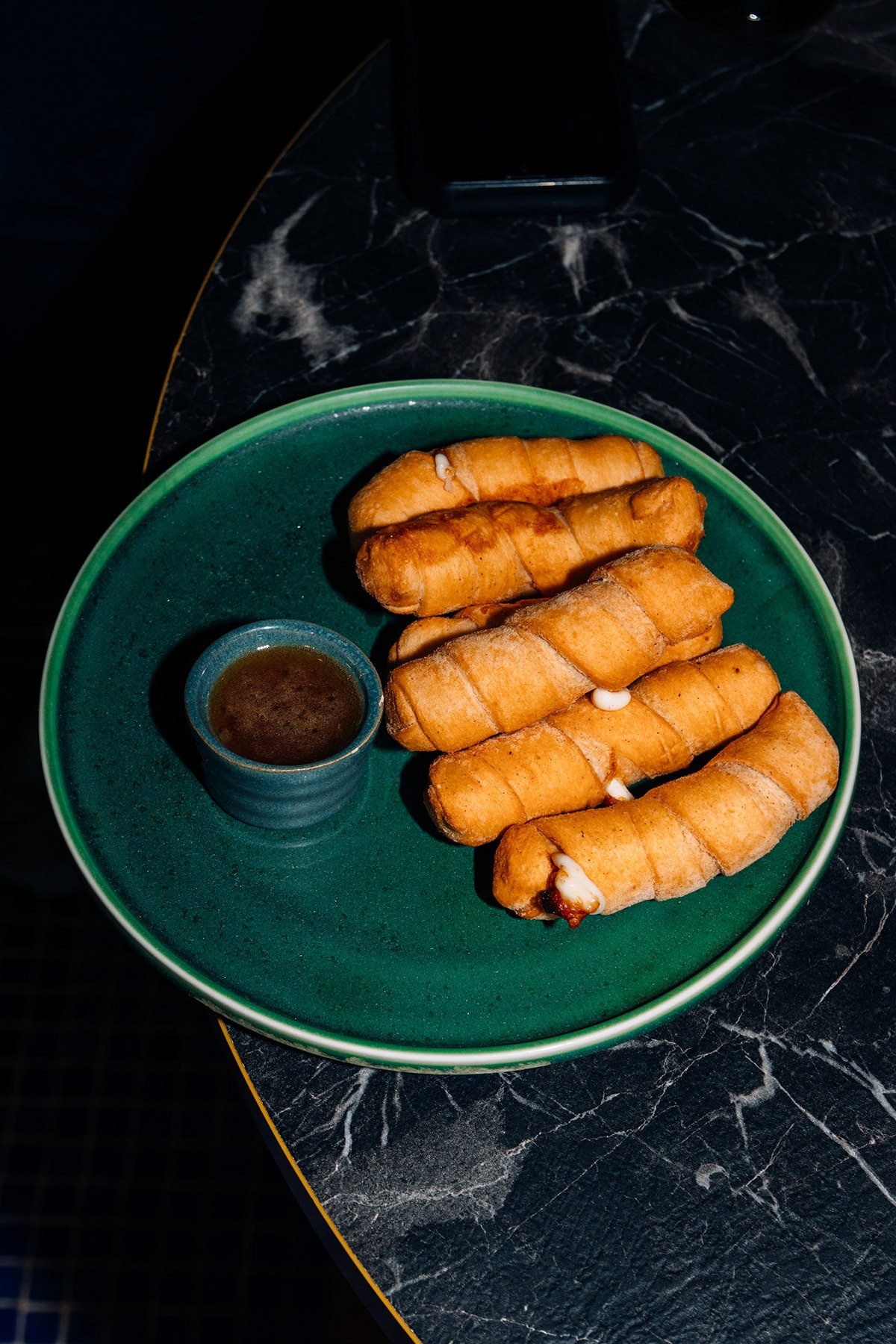 Mr Kong: tequeños con salsa en un plato verde