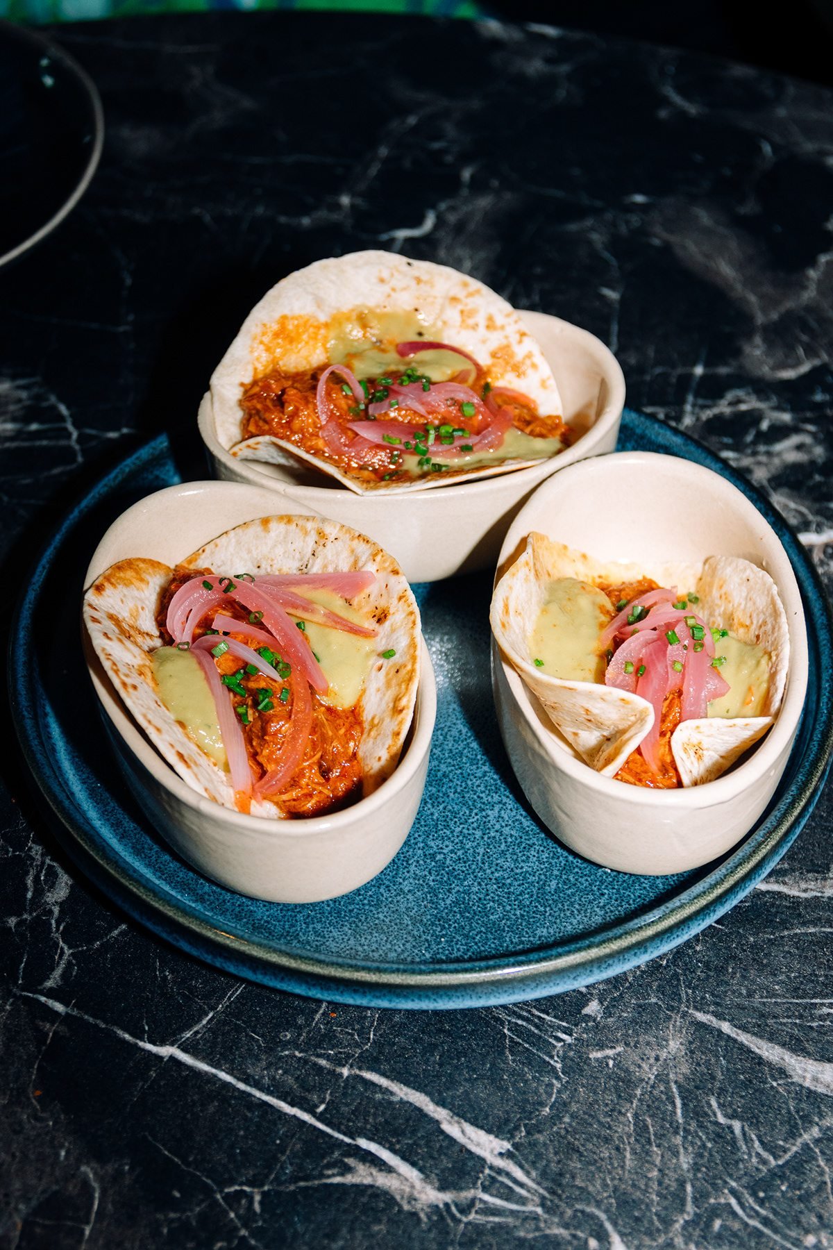 Mr Kong: tres tacos en soportes sobre un plato azul