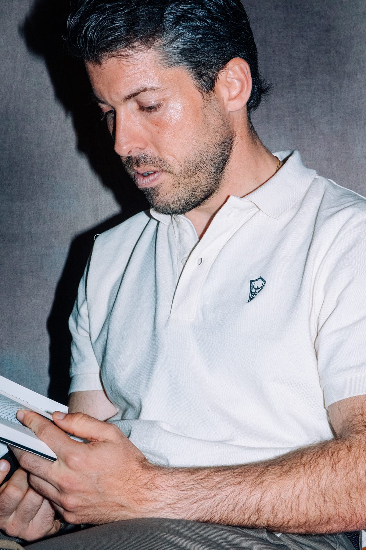Ocean Society: hombre con polo blanco leyendo un libro