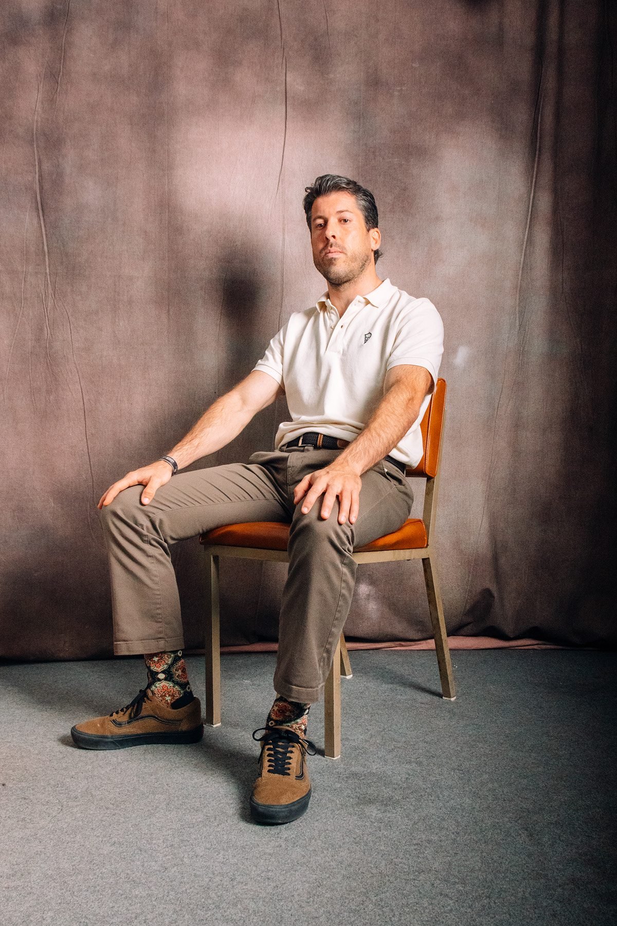 Ocean Society: retrato de hombre con polo blanco sentado en una silla