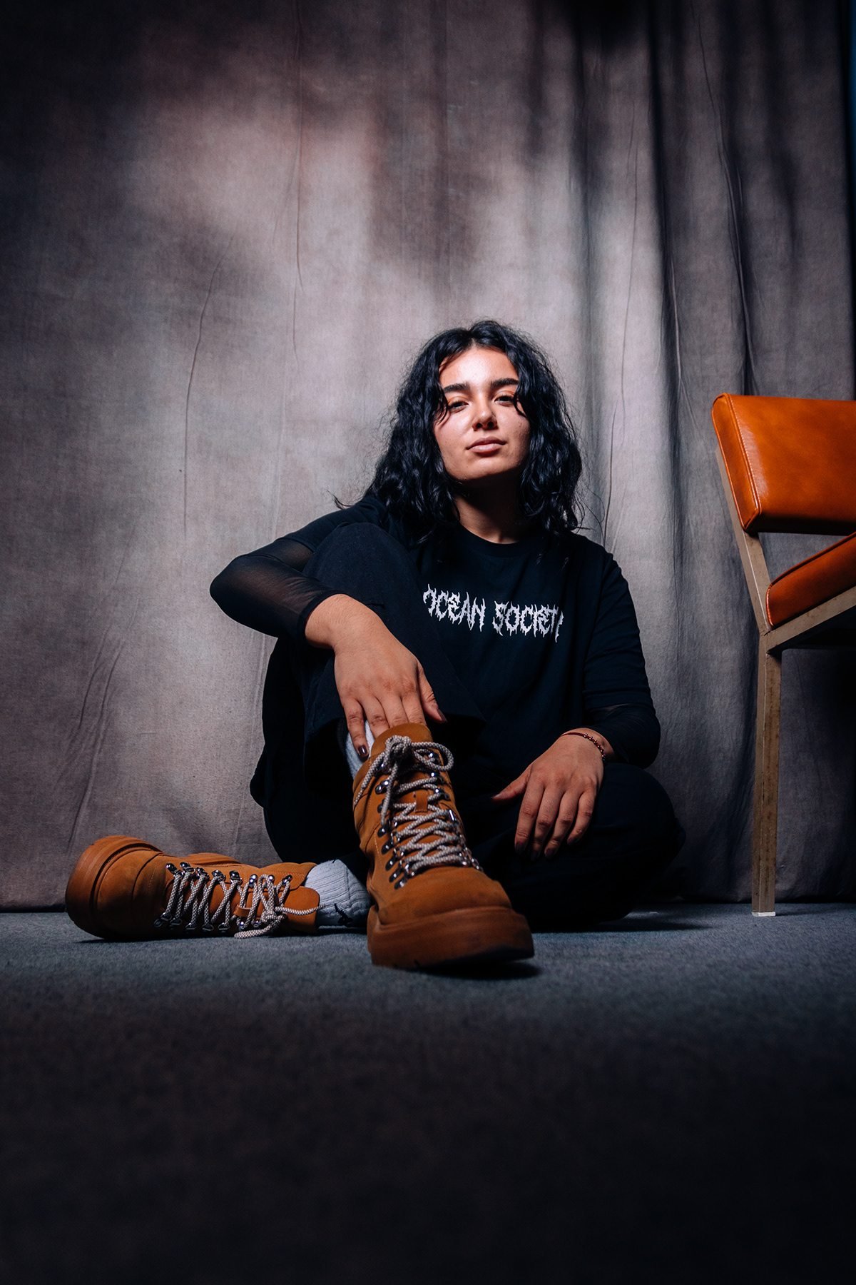 Ocean Society: mujer con camiseta negra sentada en el suelo del estudio