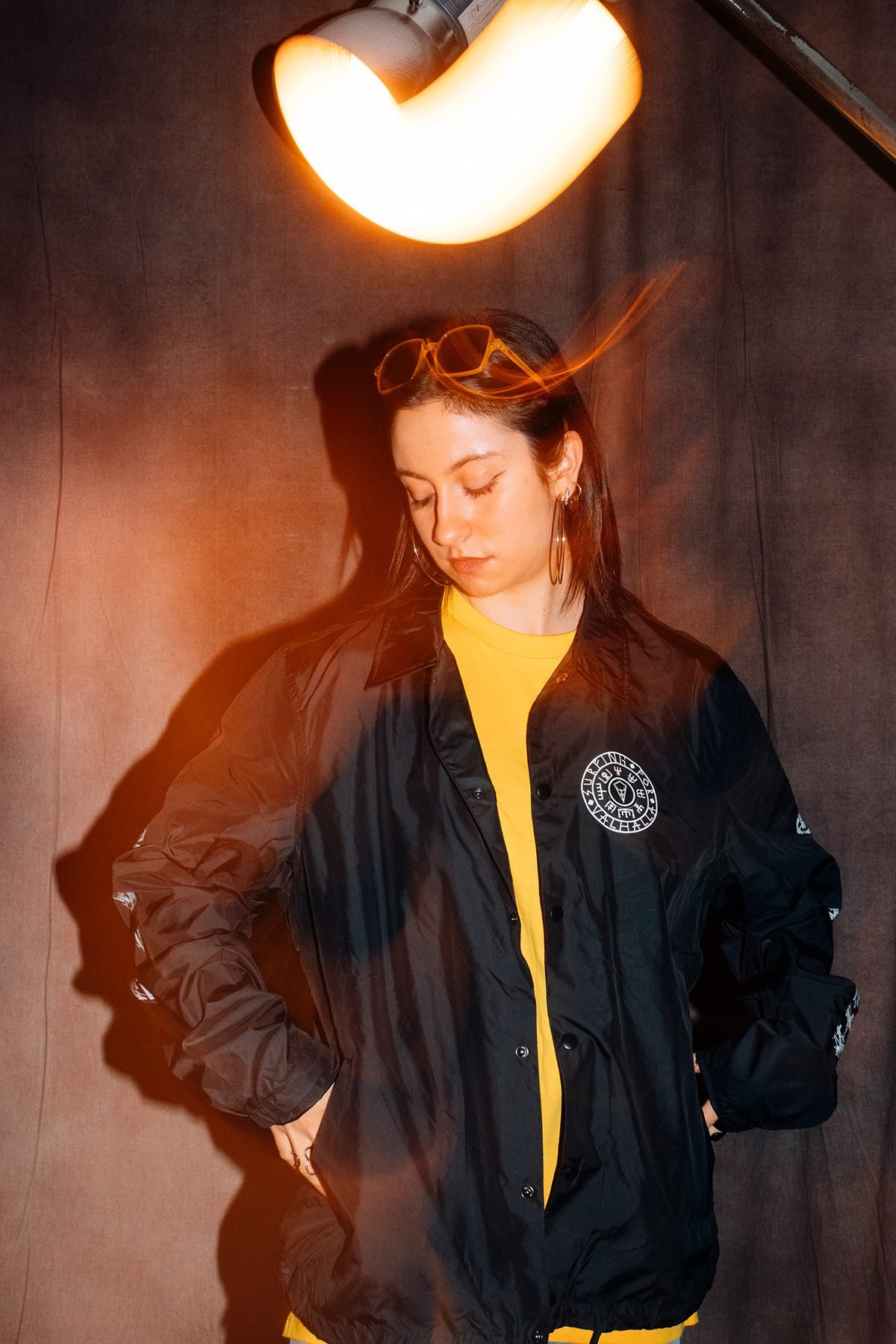 Ocean Society: modelo con chaqueta negra y camiseta amarilla bajo un foco