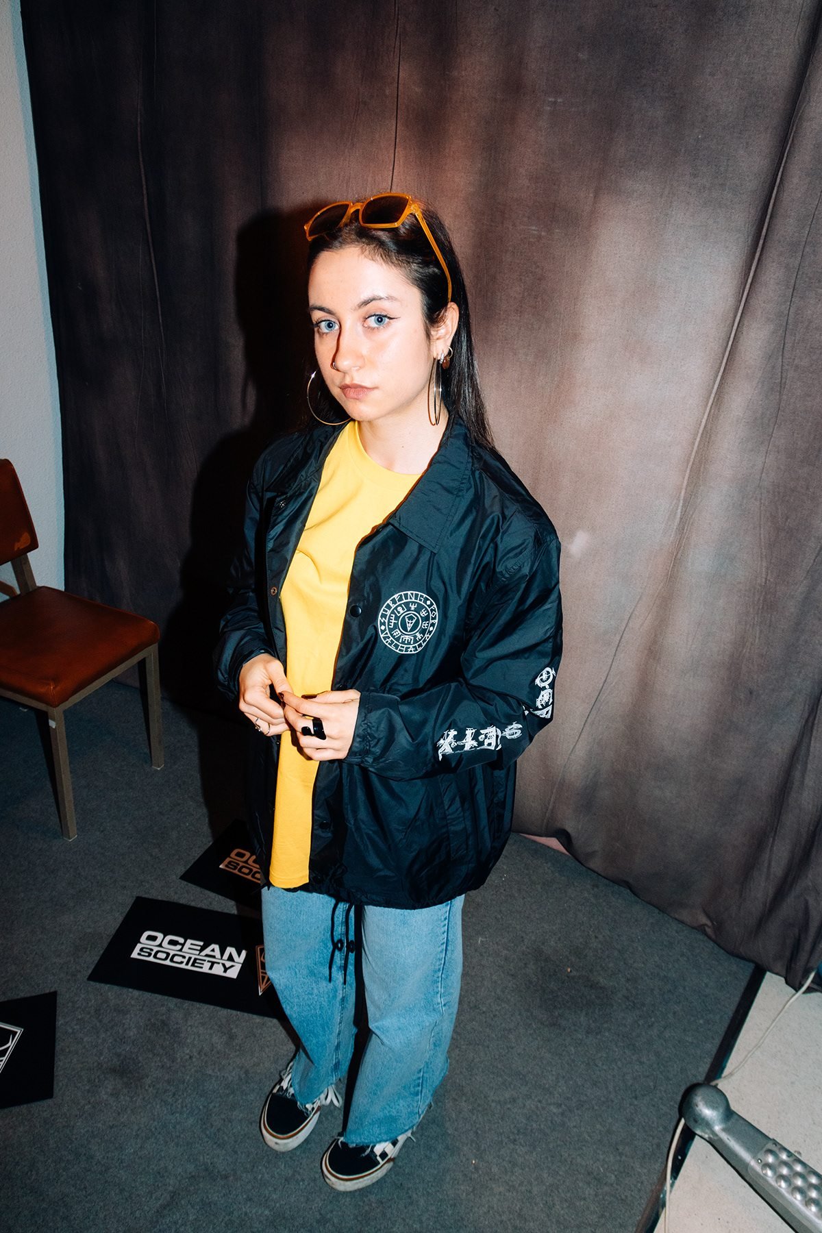 Ocean Society: modelo con chaqueta negra estampada y vaqueros en el estudio