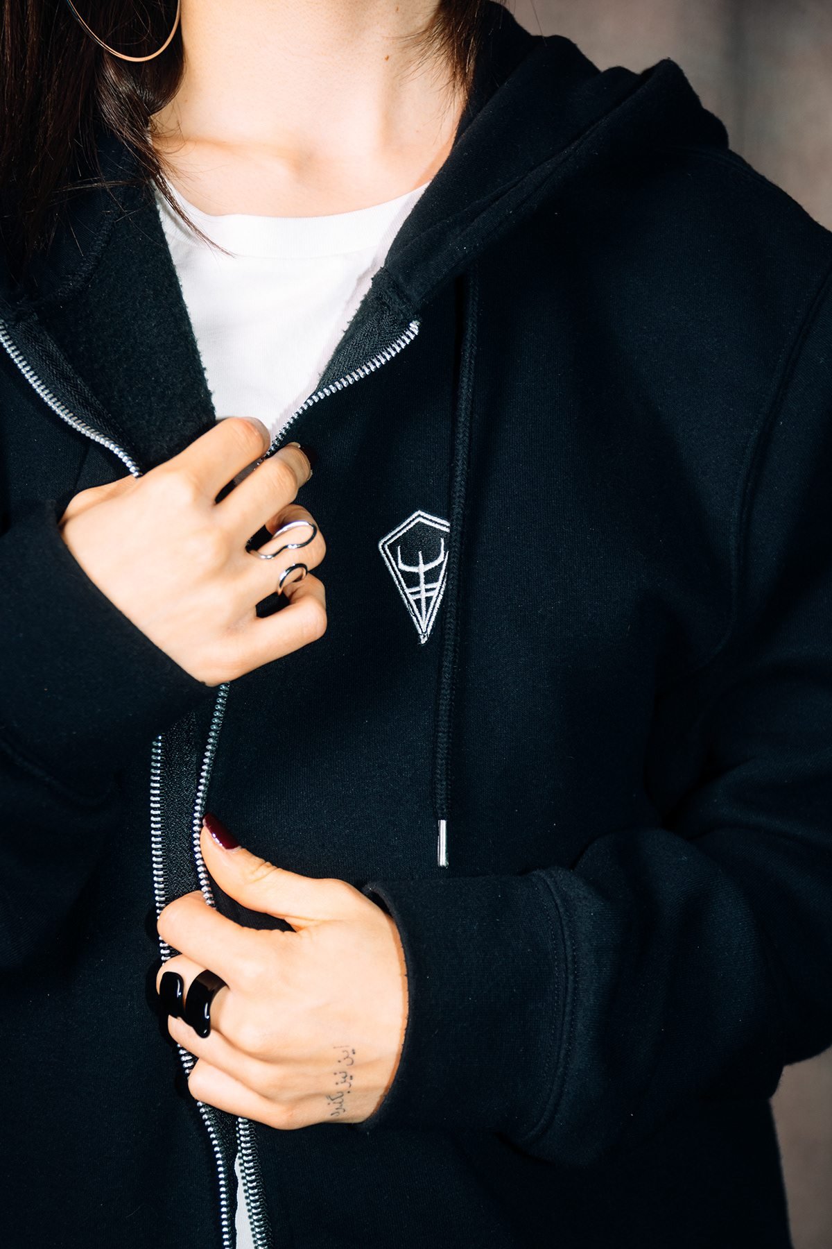 Ocean Society: detalle de sudadera negra con cremallera y logotipo