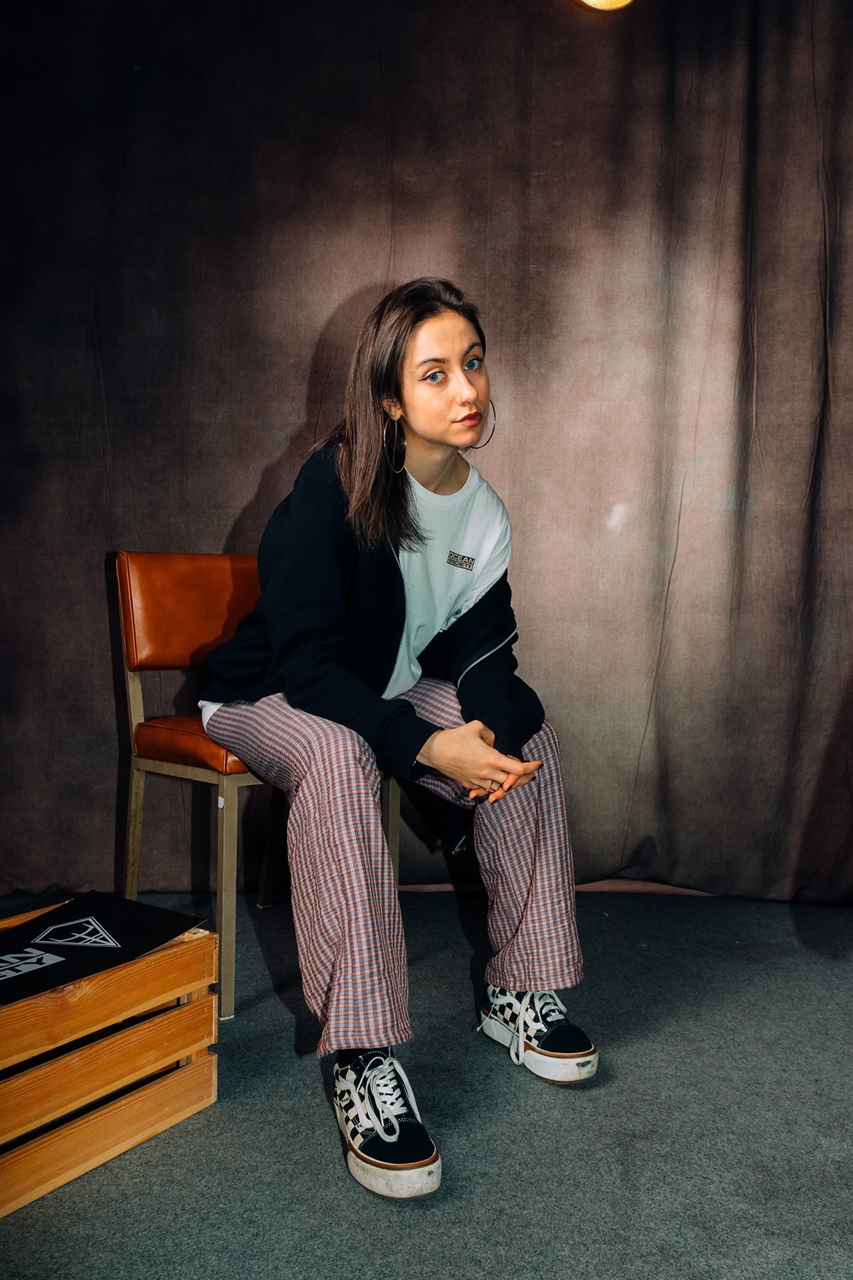 Ocean Society: modelo con sudadera negra sentada en una silla