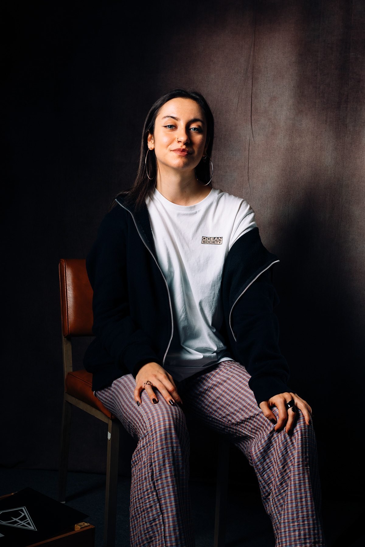 Ocean Society: retrato de modelo sentada con sudadera negra y camiseta blanca