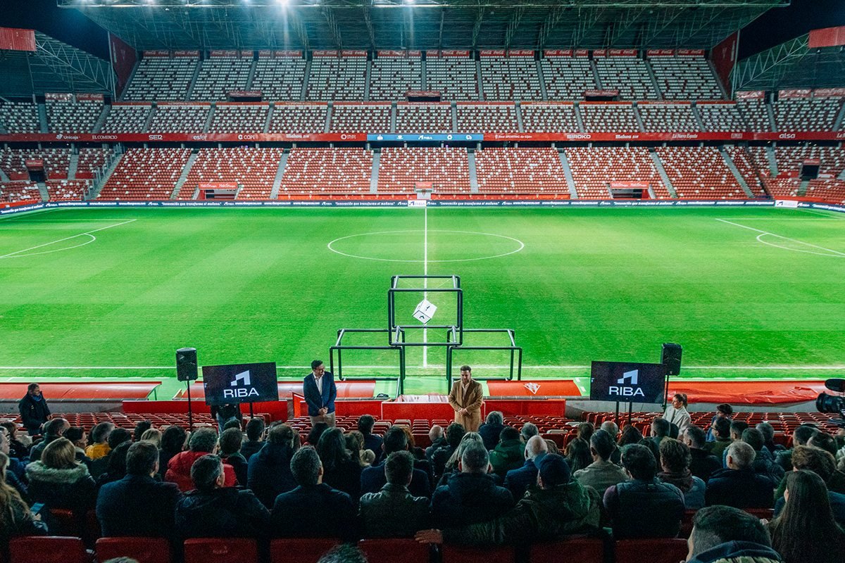 Riba Spaces: público sentado junto al césped del estadio iluminado