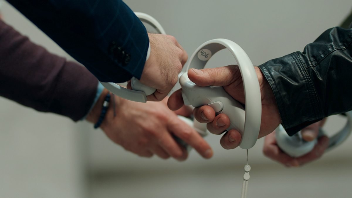 Riba Spaces: manos entregando un mando de realidad virtual