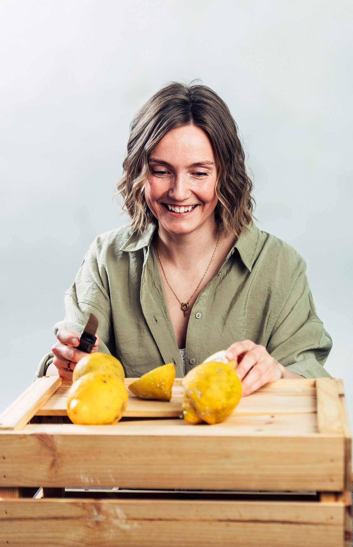 Vilma: mujer cortando limones sobre una caja de madera