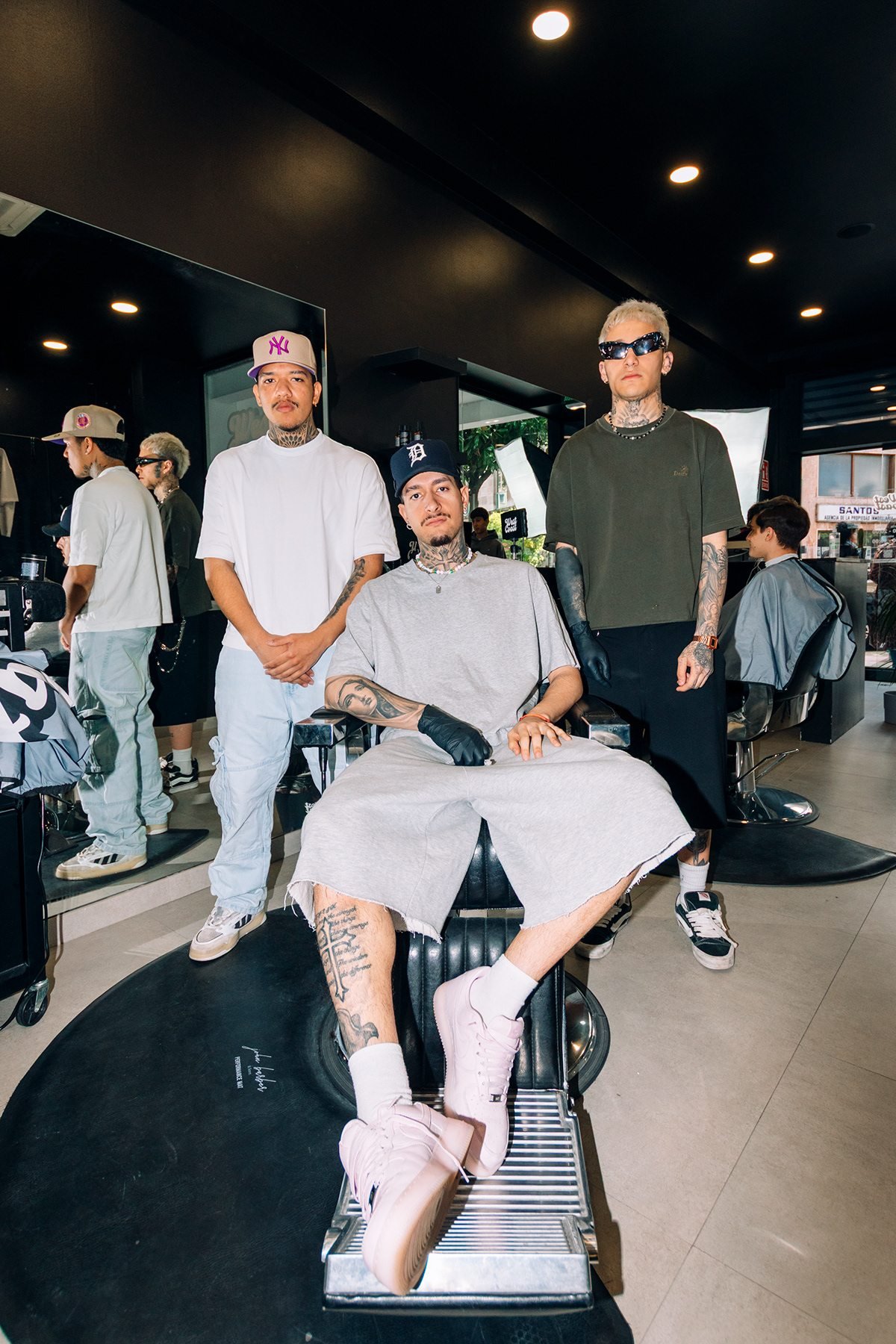 West Coast: equipo y cliente posando alrededor del sillón de la barbería