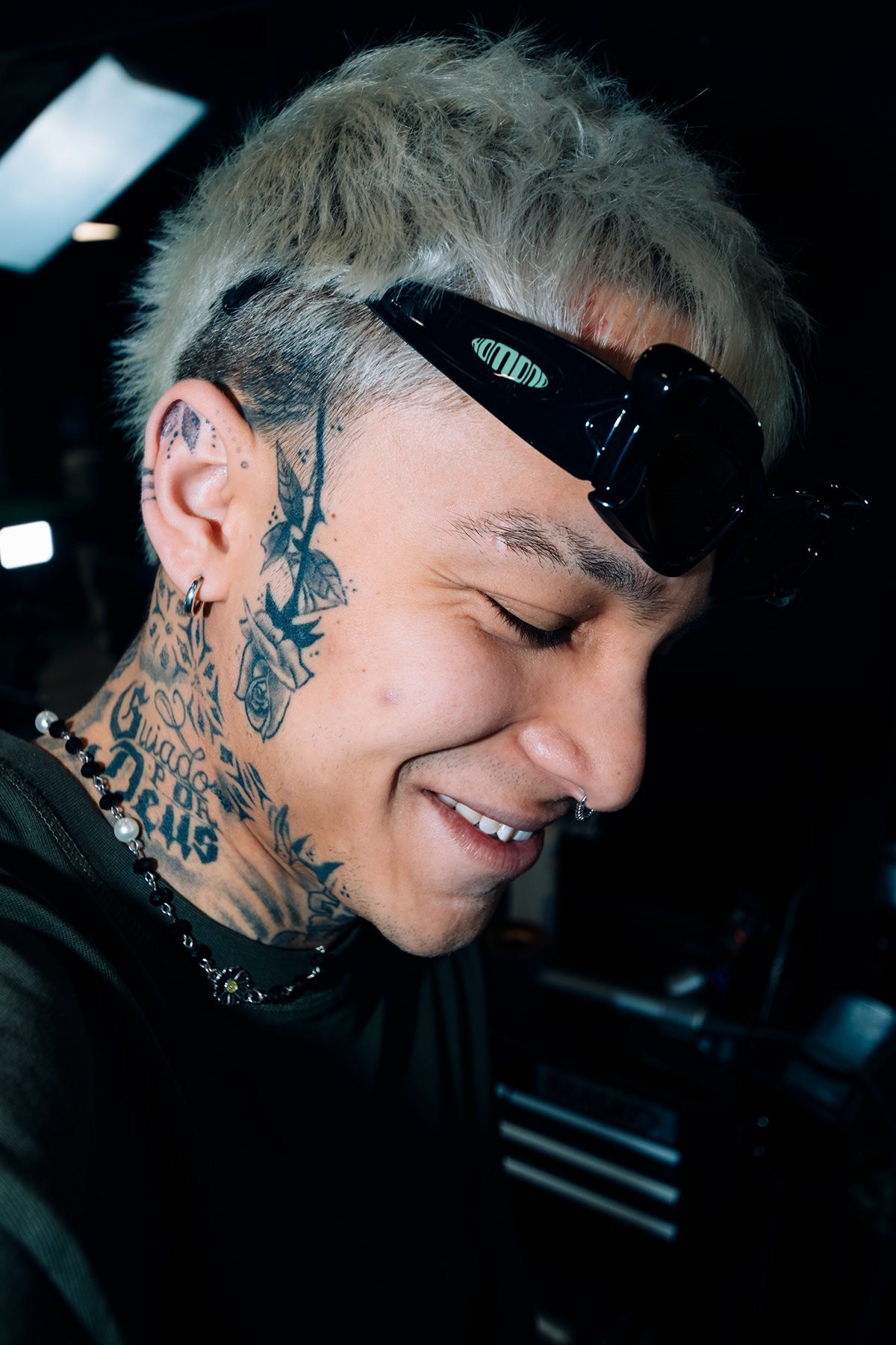West Coast: retrato de barbero sonriente con tatuajes en el cuello