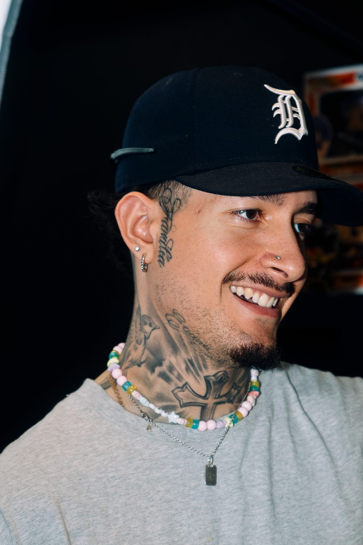 West Coast: retrato de hombre sonriente con gorra y collar de cuentas