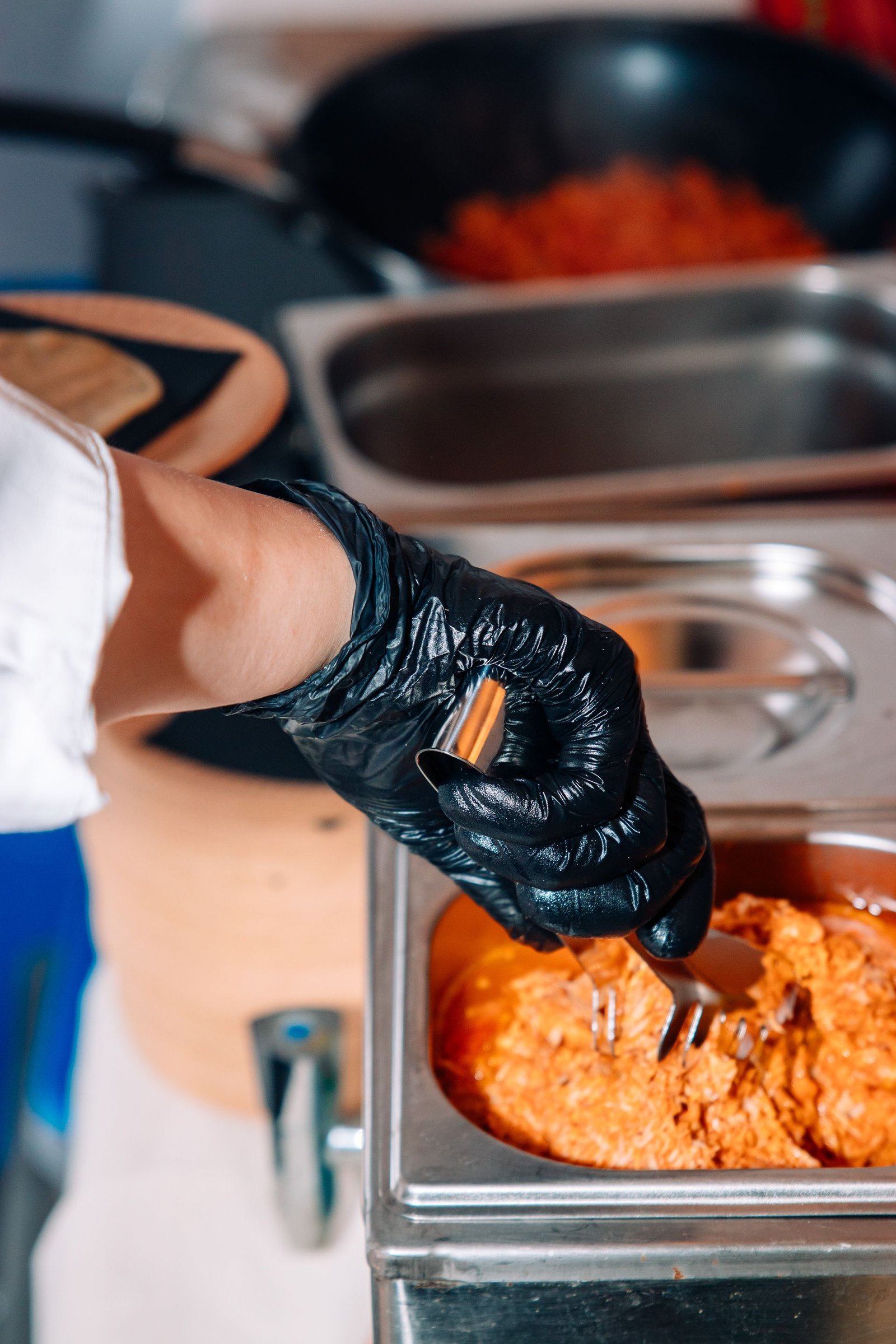 Primer plano de una cocinera terminando un plato caliente.