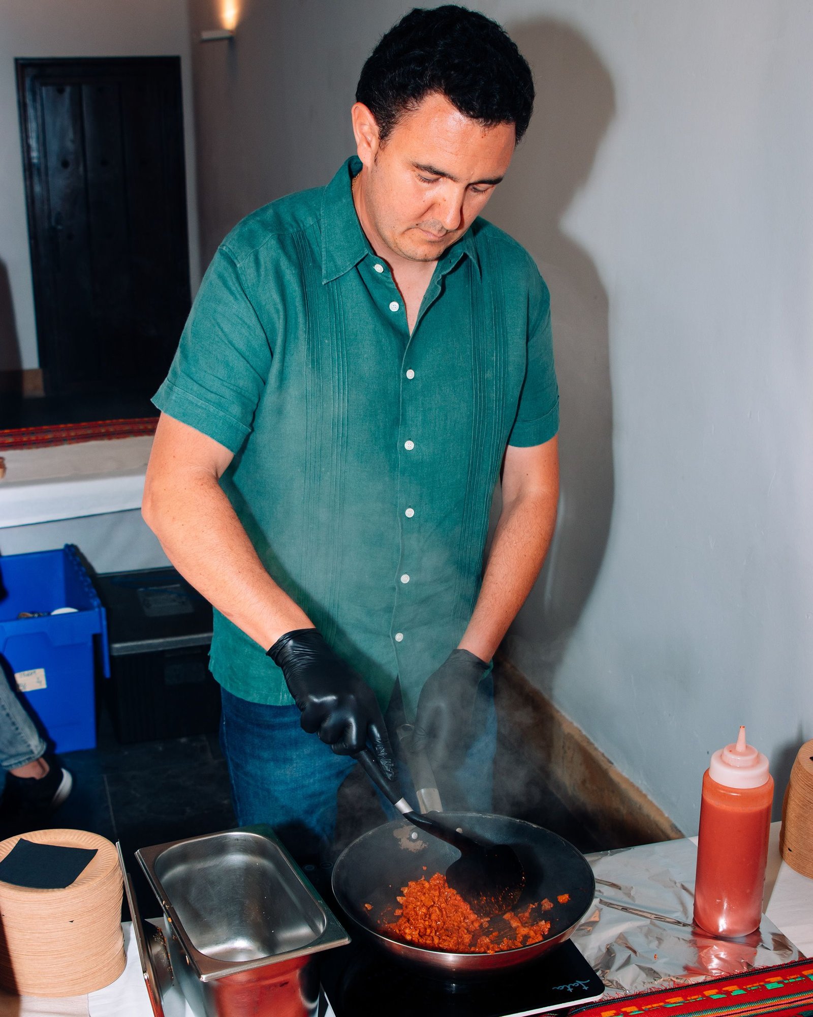 Manos cocinan una preparación en una sartén.