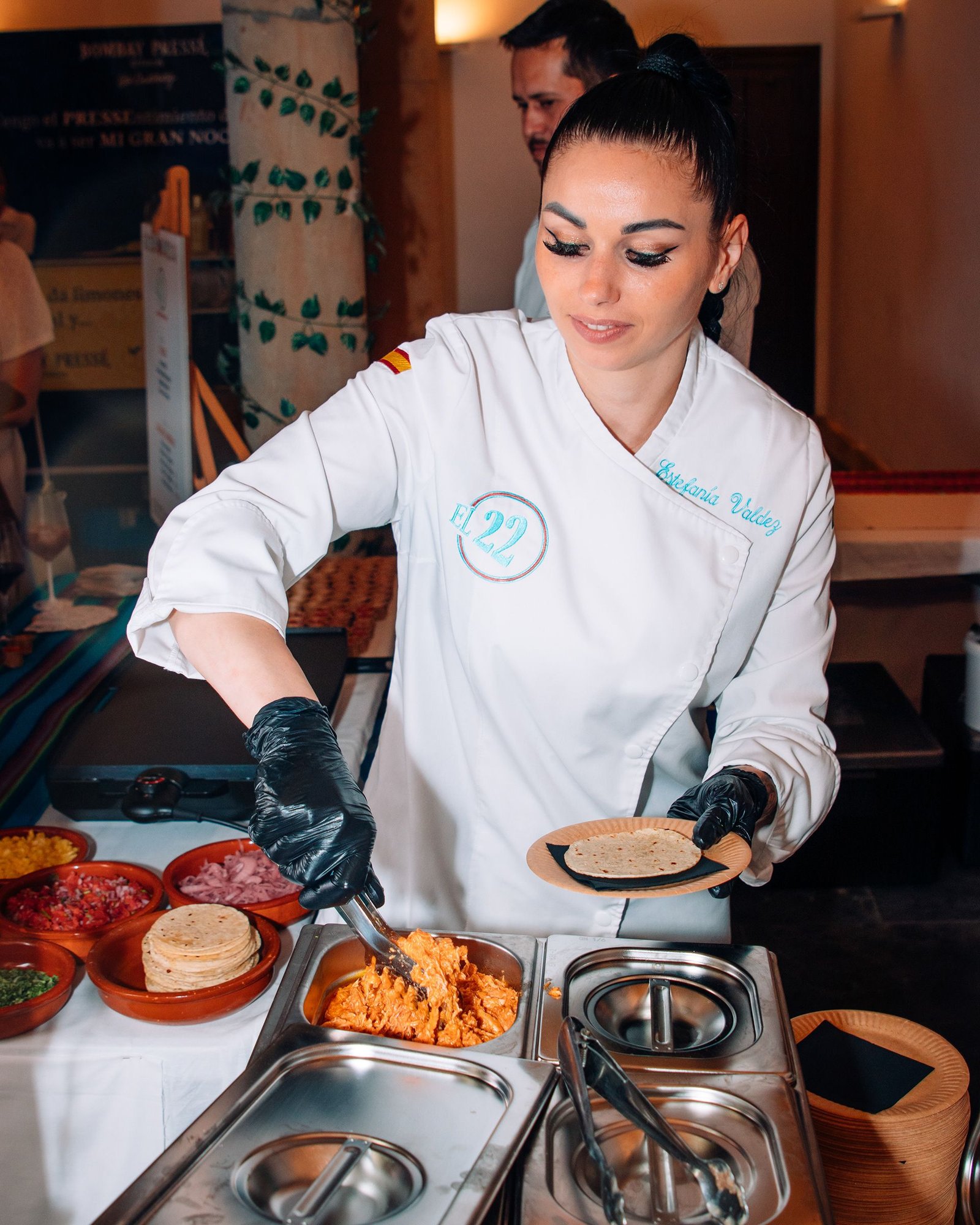 Equipo de cocina trabaja alrededor de una mesa con platos.