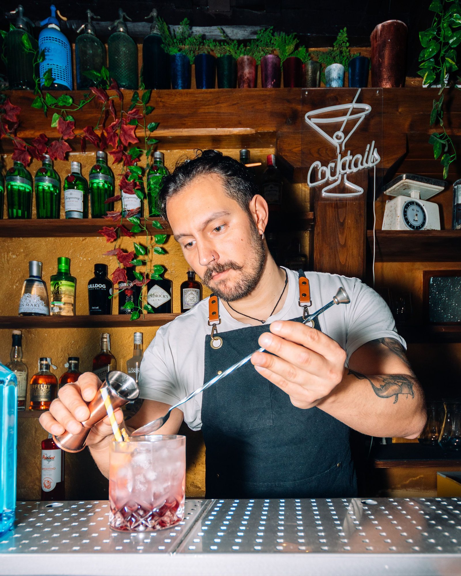 Barista presenta un cóctel preparado detrás de la barra.