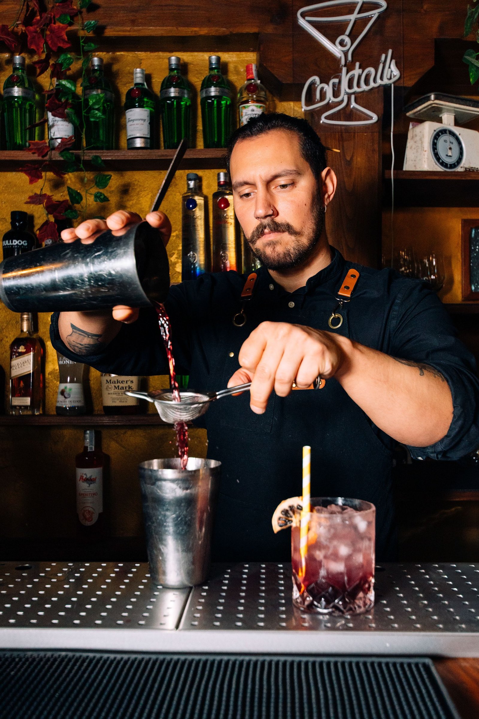 Barista termina un cóctel junto a la barra.