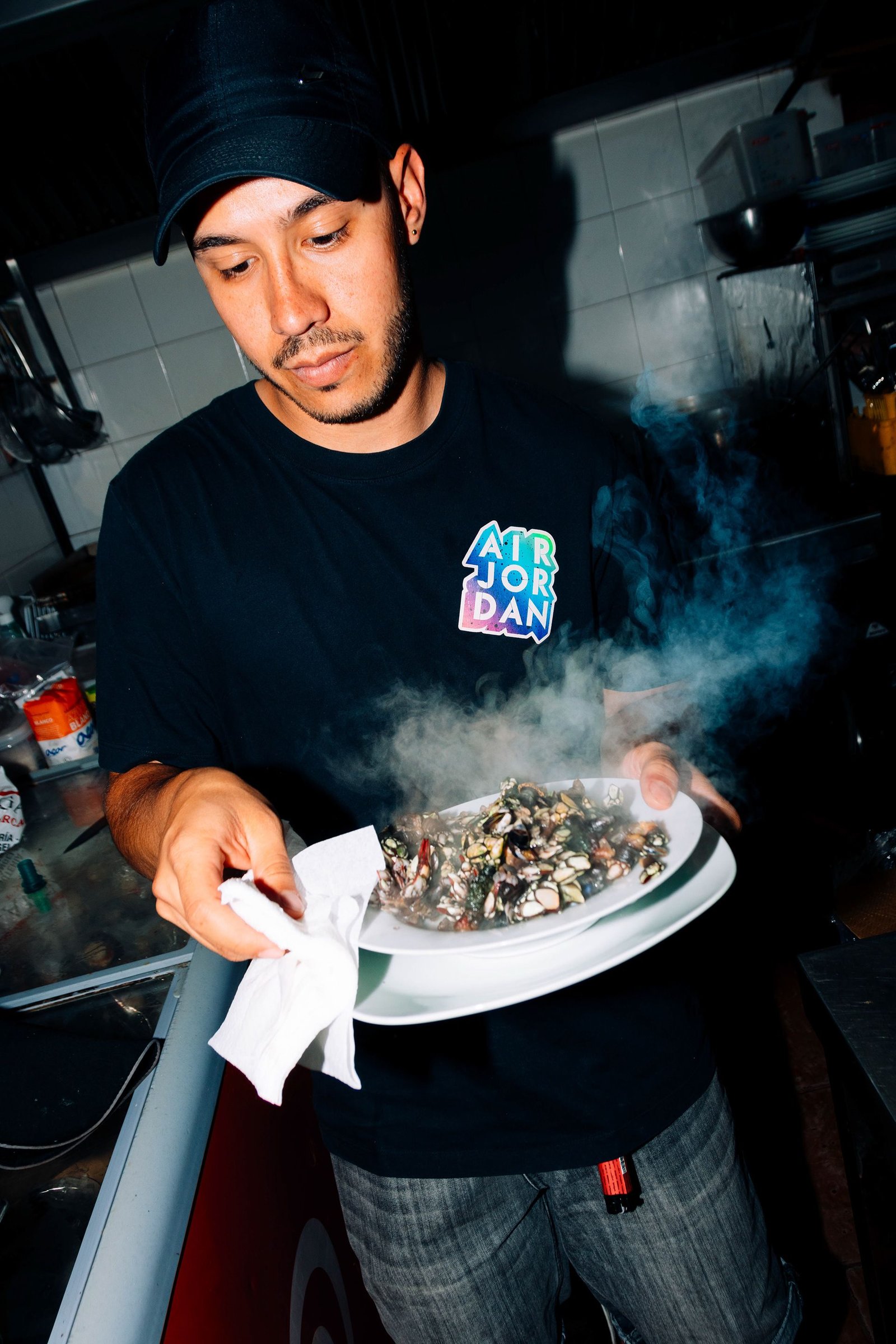 Camarero presenta un plato en la cocina del restaurante.
