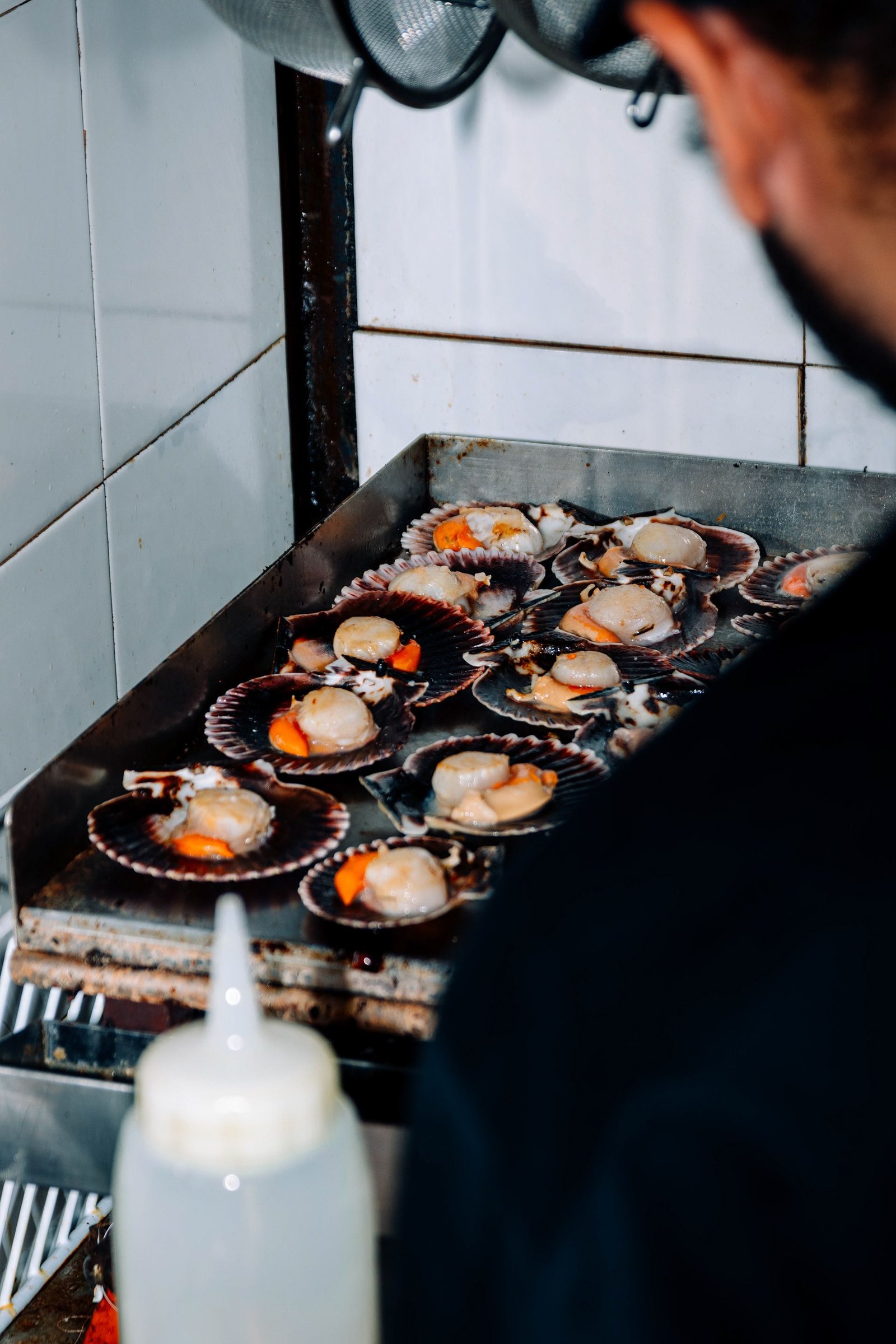 Cocinera coloca comida en una bandeja de servicio.