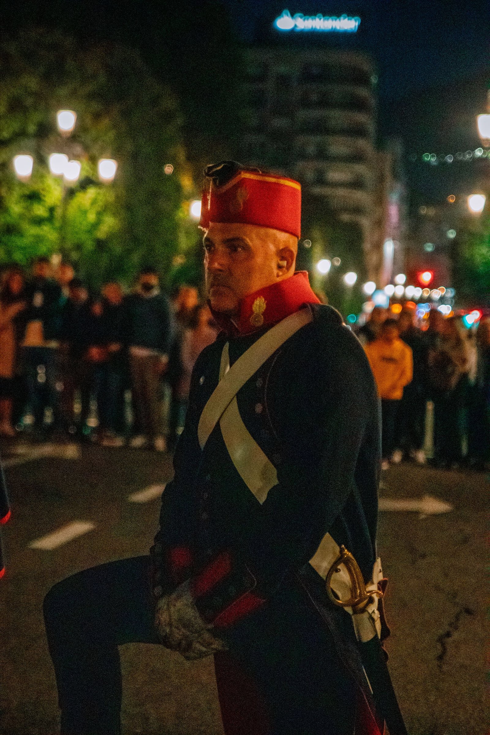 Participante con sombrero rojo y capa durante el desfile.