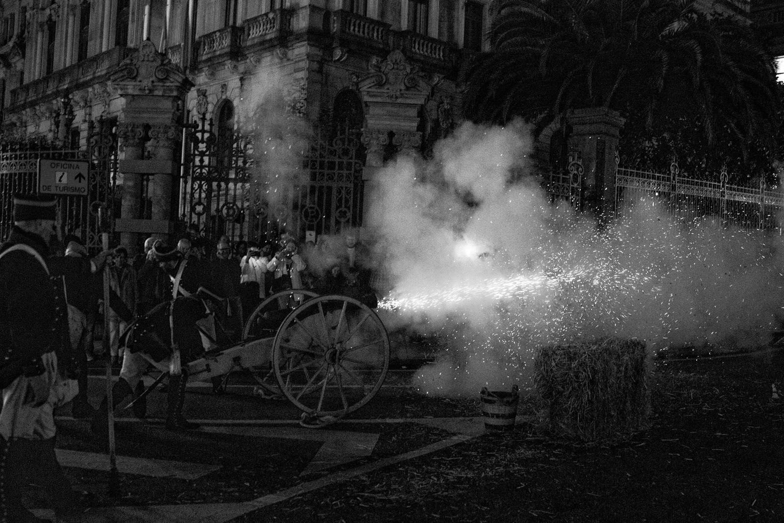 Carroza y asistentes entre humo iluminado durante la celebración nocturna.