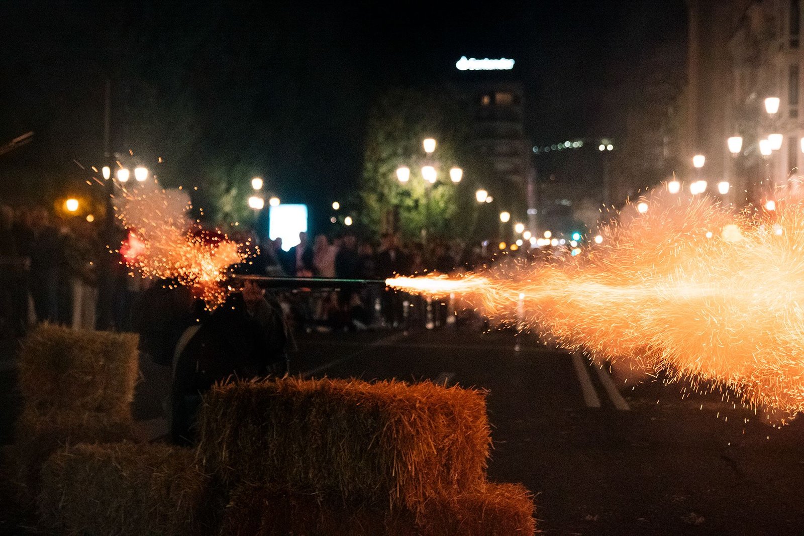 Chispas de luz cruzan sobre el público de la celebración nocturna.