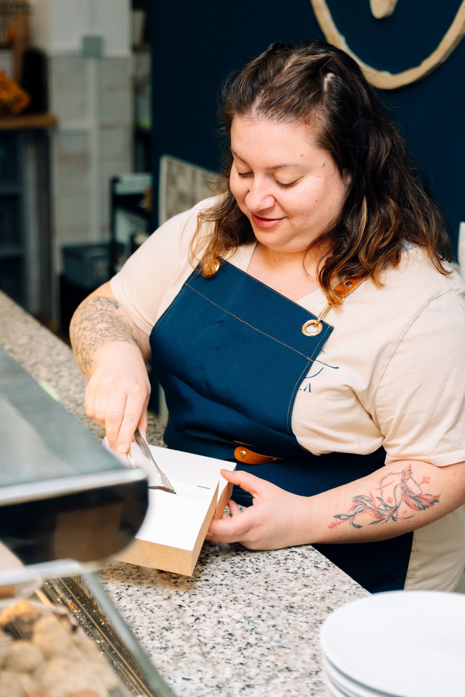 Profesional de cocina posa junto a la mesa de trabajo.