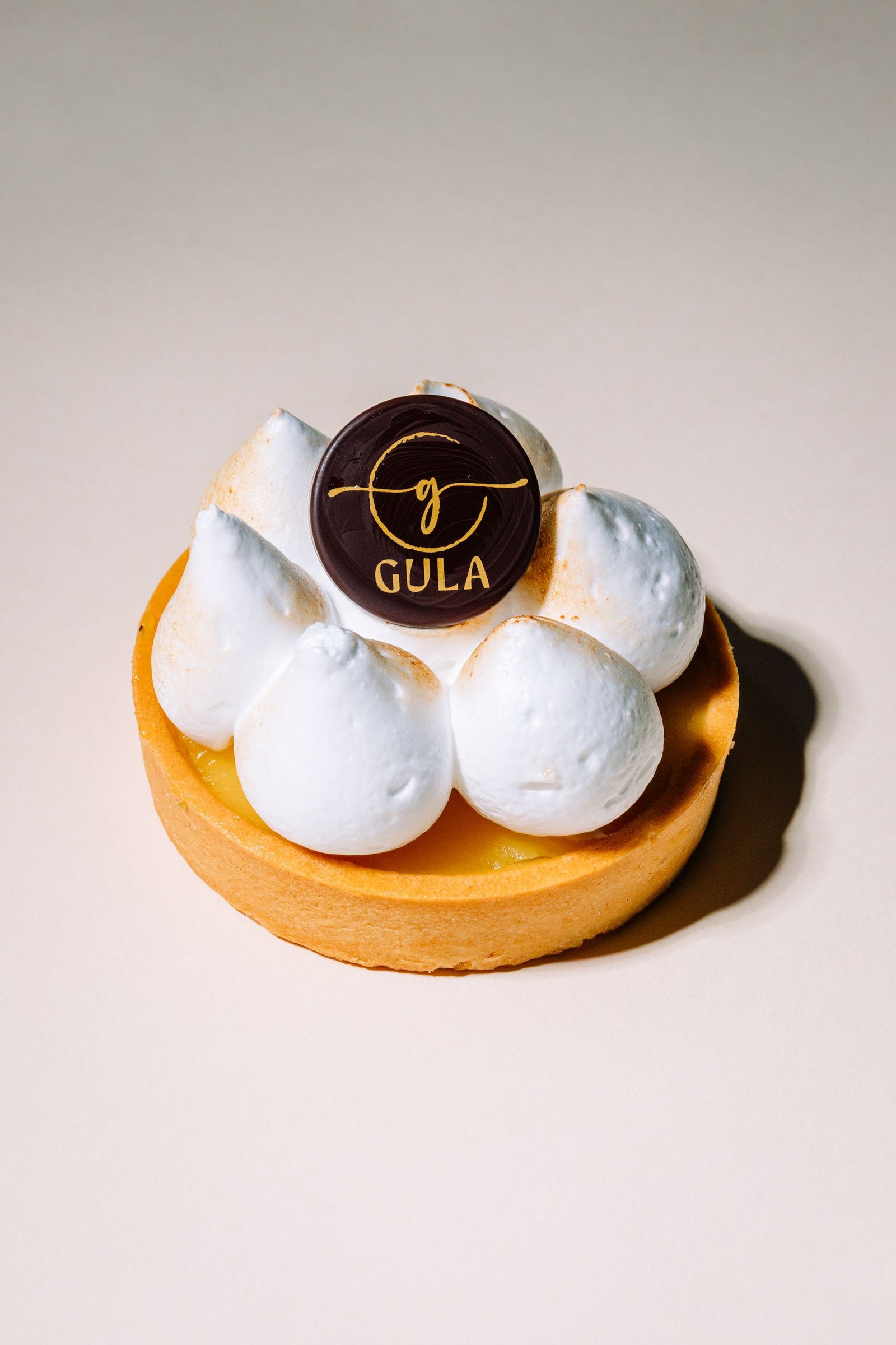 Pastel pequeño de crema blanca presentado sobre fondo claro.