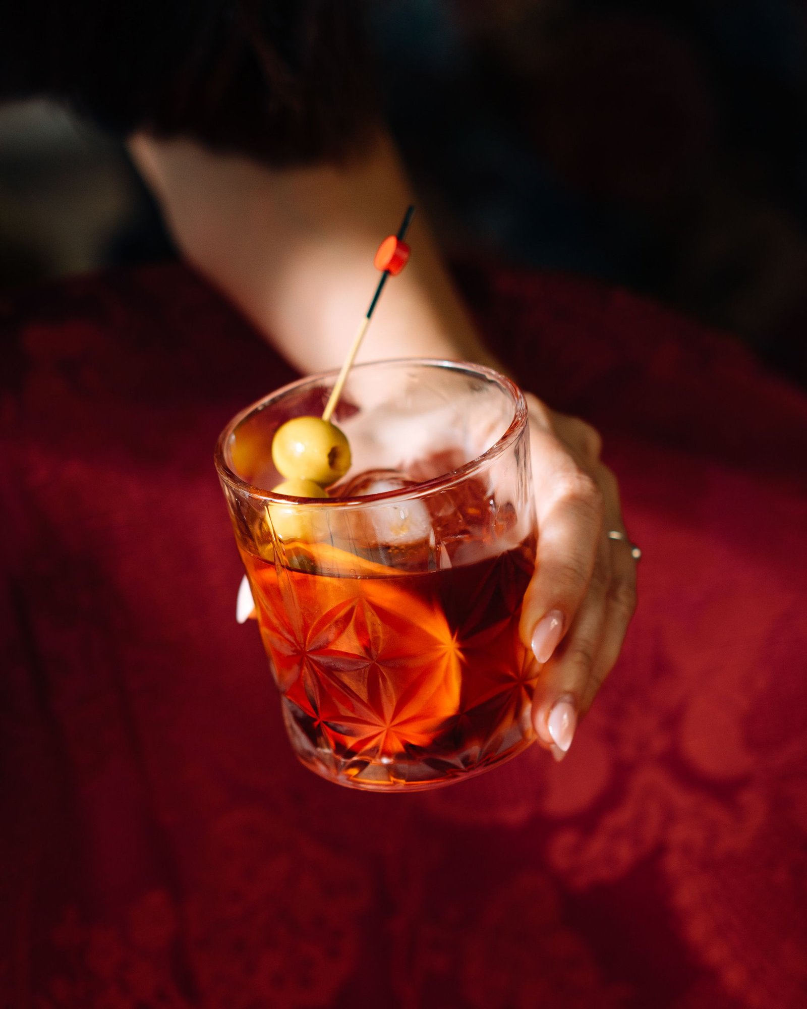 Copa con bebida de color ámbar y una rodaja de naranja.