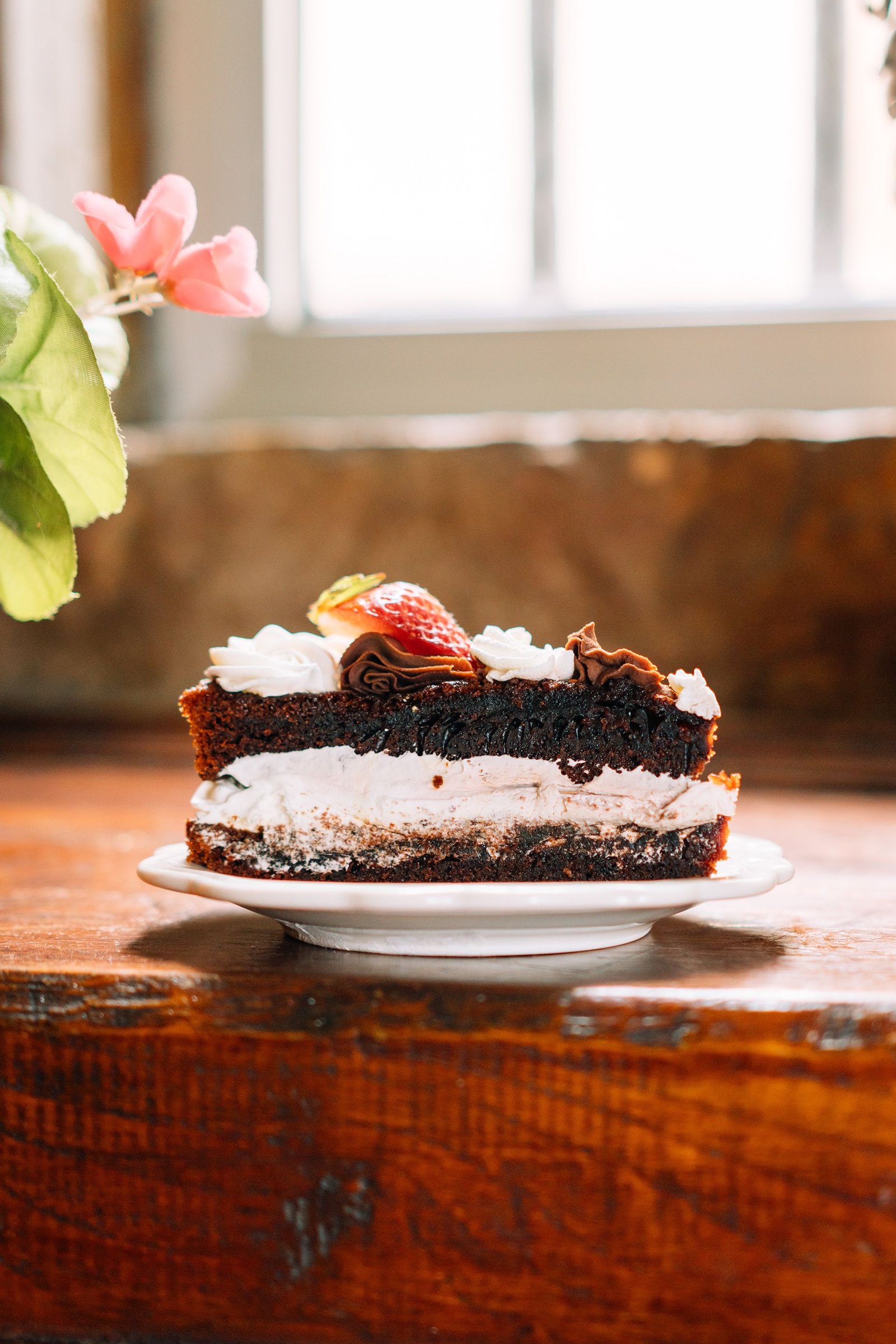 Porción de tarta con cobertura blanca presentada en un plato.