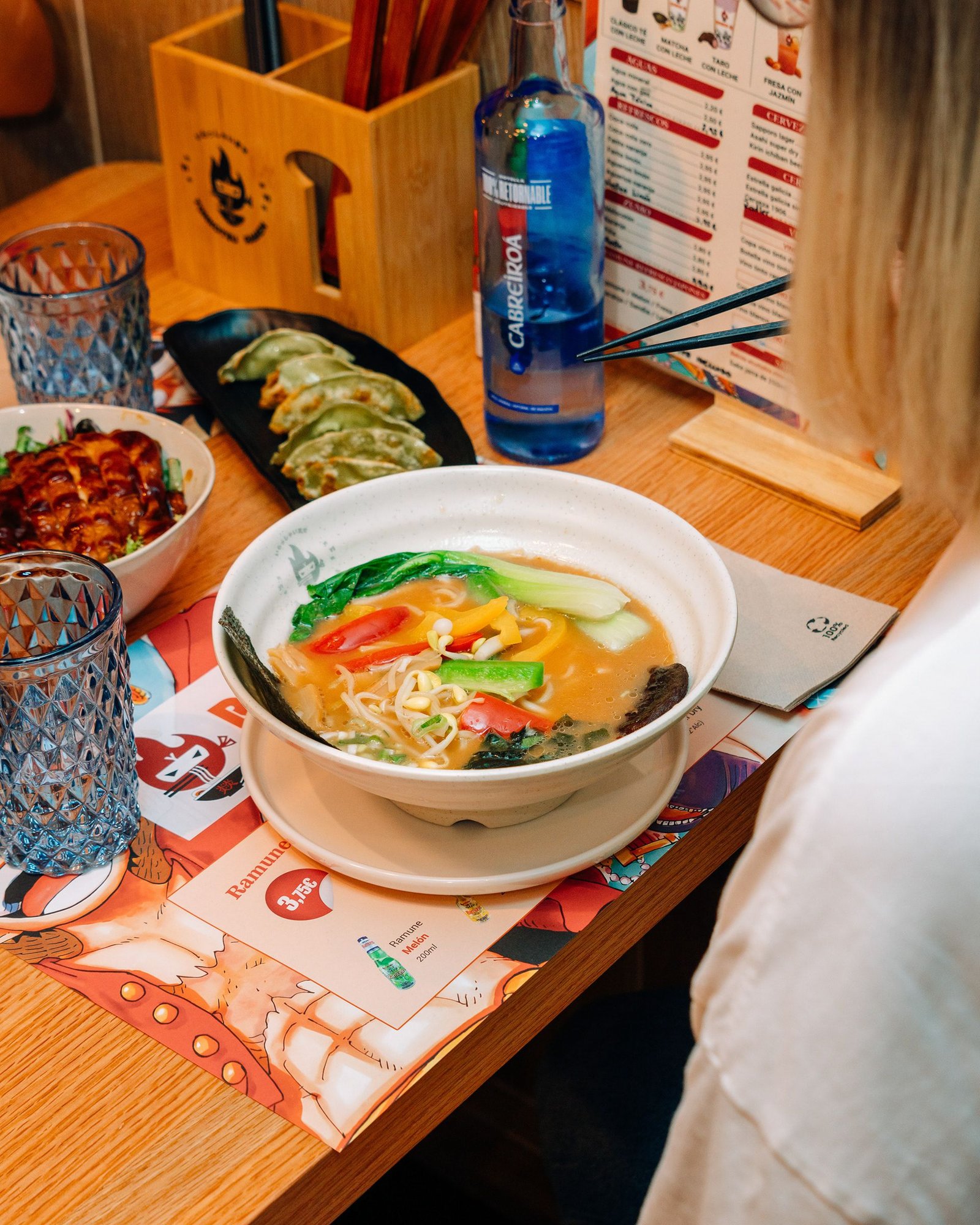 Bowl de ramen con huevo y guarniciones sobre la mesa.