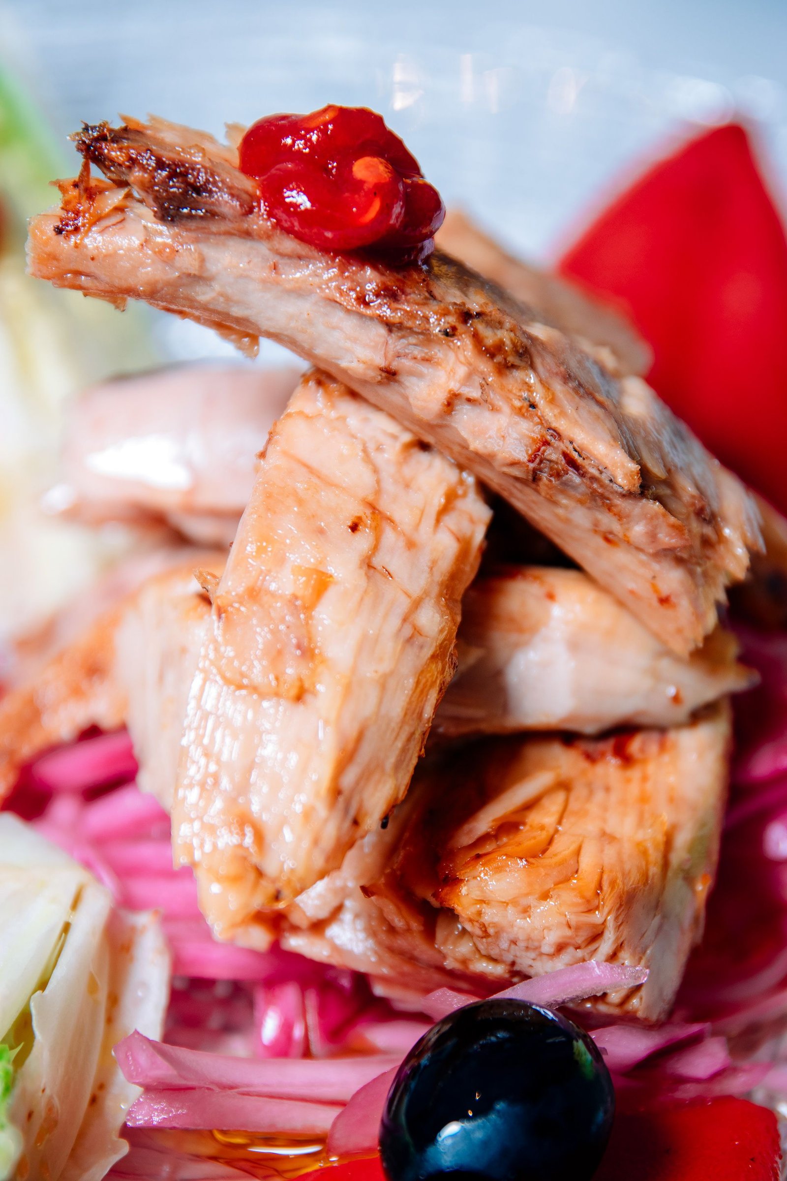 Piezas de pollo servidas con hierbas y salsa.
