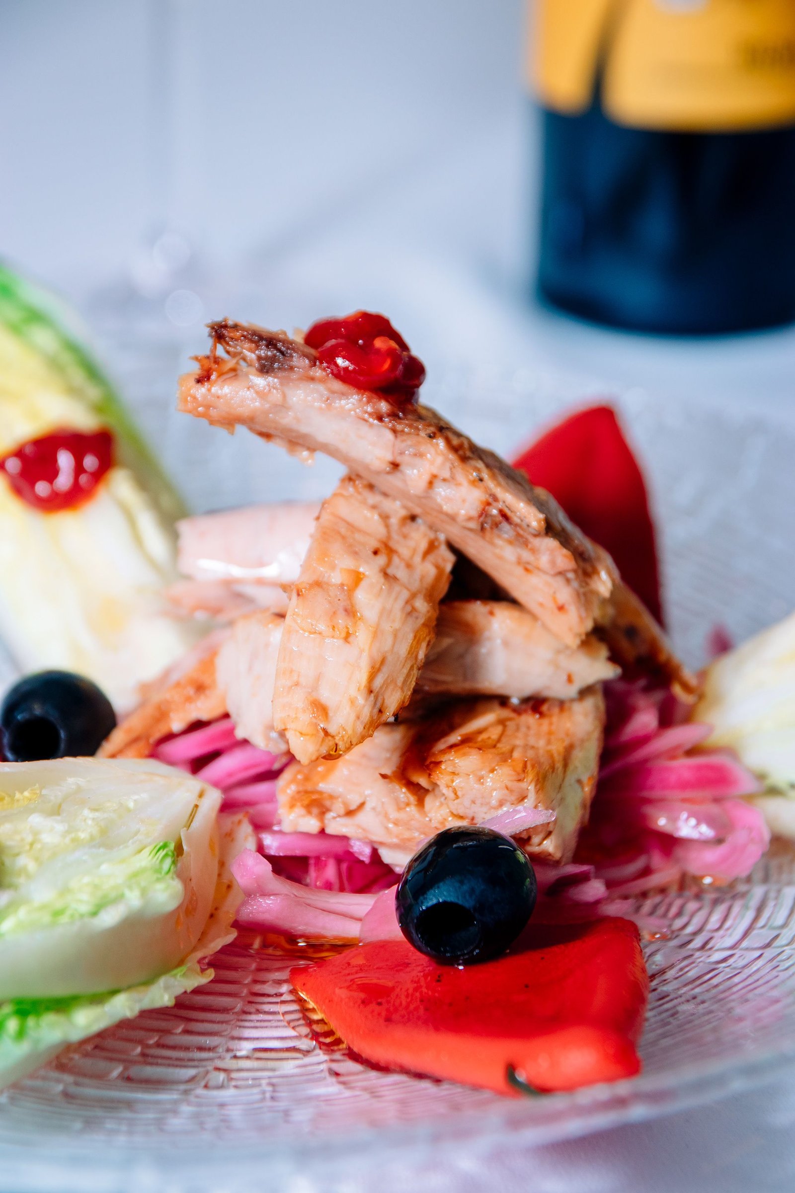 Pollo presentado en un plato con guarnición verde.