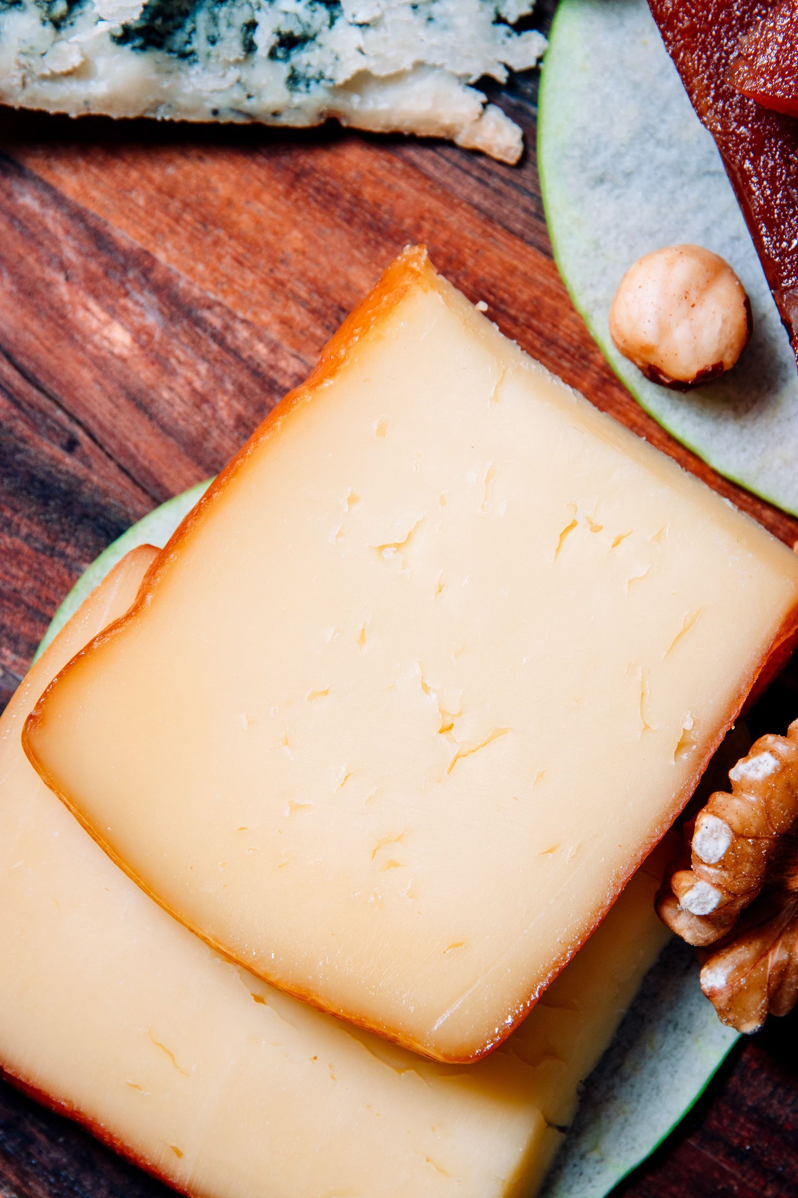 Trozo de queso presentado sobre una tabla de madera.