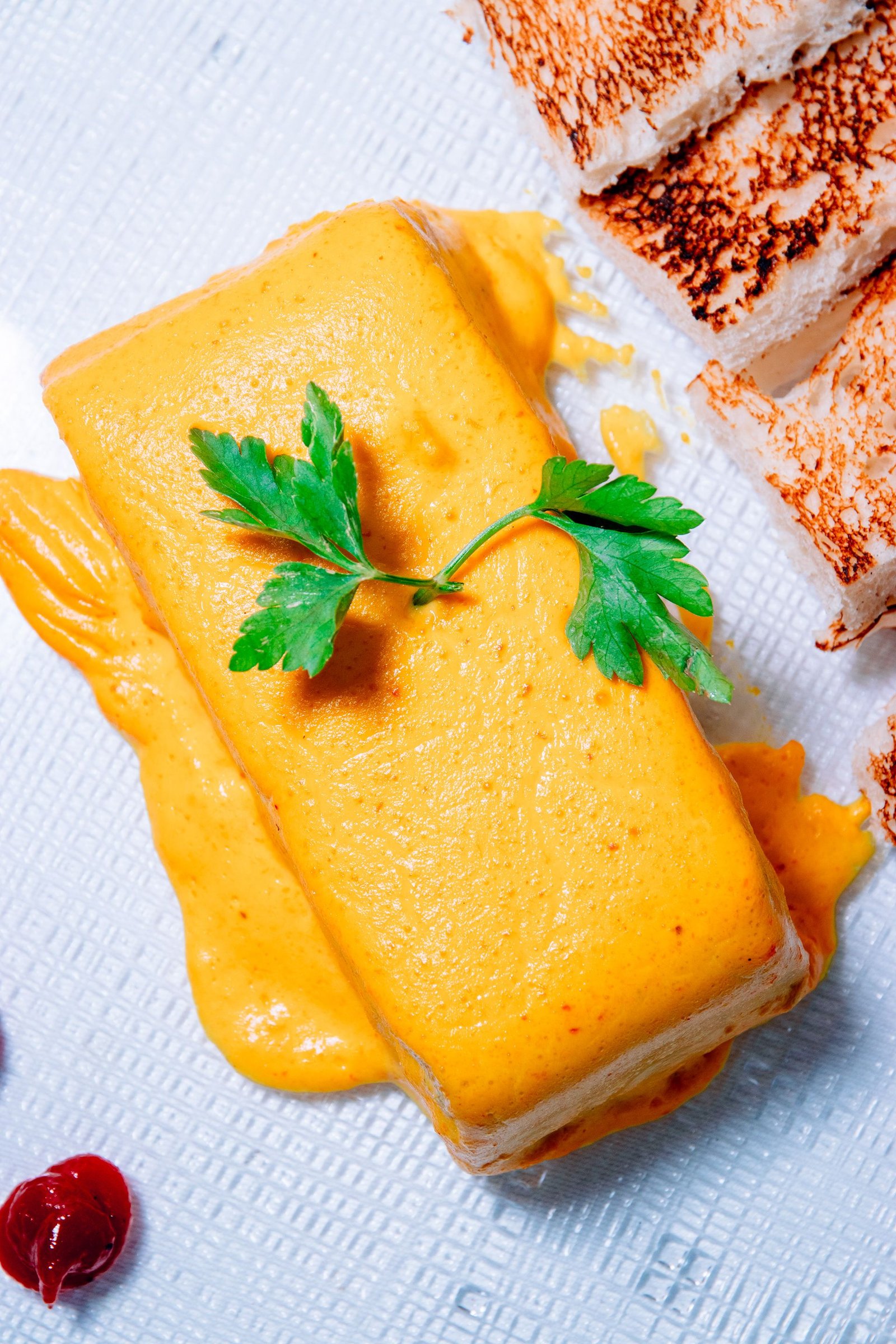 Bloque de queso amarillo presentado sobre la mesa.