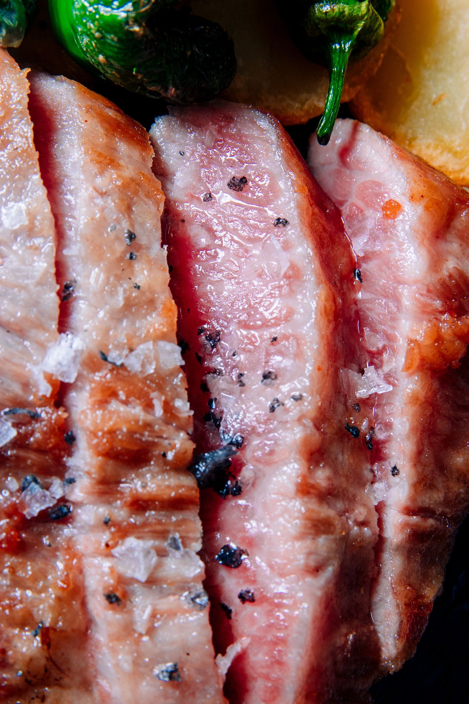 Detalle de piezas de carne sobre una tabla oscura.