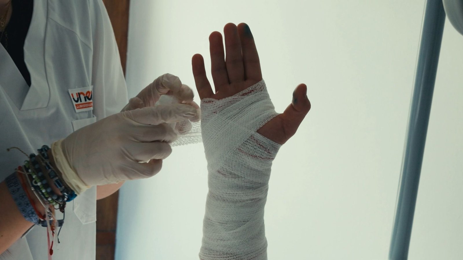 Manos con guantes vendan la mano de un compañero.